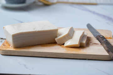 White square tofu cubes On a wooden cutting board and a knife