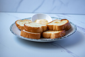 Toasts in a plate with cheese on a gray background