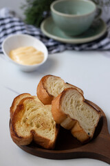 Toast in wooden plate with cheese on gray background