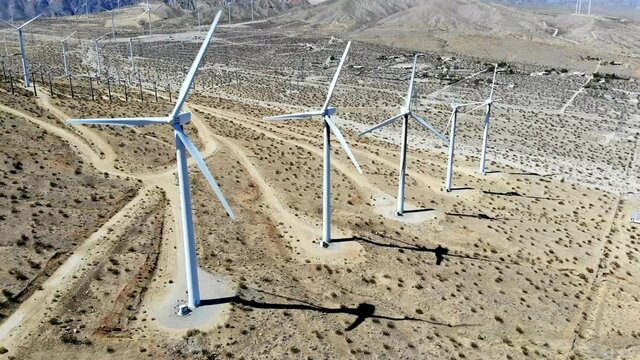 Windmills, wind turbines- aerial 4k drone push in, high angle, energy, green, renewable, huge power generating farm on desert hills, in Palm Springs, Coachella Valley, Cabazon, California