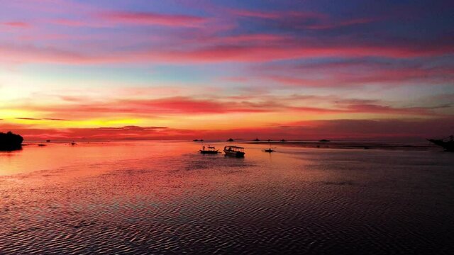 Colorful sunset and fishing boats in Philippines.