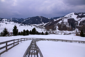 Naklejka premium Quiet bob track in winter on the mountain. Beautiful mountains in background