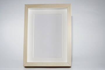 Picture frame with wooden frame photographed frontally in the studio with shadows