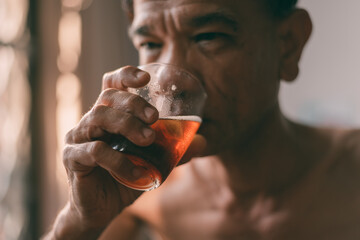 Liquor glass in the hands of a middle-aged man, concept of poor man alcohol addiction and depression because of life problems, Strain during the economy has stalled due to covid pandemic, Cinema tone.
