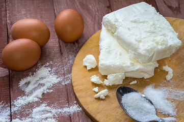 Cottage cheese and eggs on the table. Products for curd cakes. Cooking cottage cheese.