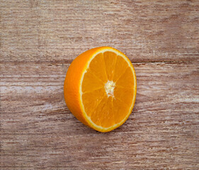 Half an orange on a wooden table. Banner with orange. Orange on a wooden background.