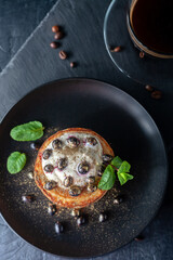 Freshly prepared homemade pancakes with sour cream and fresh berries with a cup of fragrant coffee