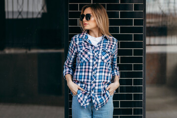 Fashion portrait of beautiful woman with beautiful face, wearing grunge plaid shirt. Posing alone.