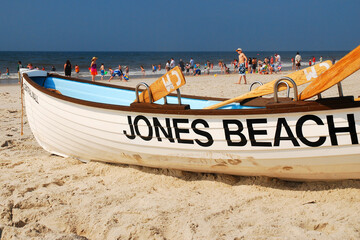 A life guard boat is planted on the sands of Jones Beach, Long Island on a sunny summer's day - obrazy, fototapety, plakaty