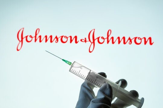 Kyiv, Ukraine – April 18, 2021: Coronavirus Vaccine Concept. The syringe Injection is placed against Johnson and Johnson logo. JnJ coronavirus vaccine..