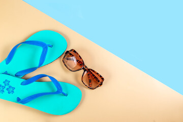 Beach slippers, flip-flops, sunglasses and a camera on the seashore. Summer vacation concept....