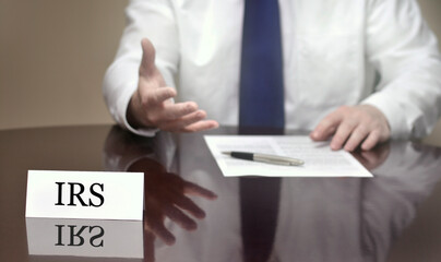 Business Man Businessman at Desk with Papers and Card Making Hand Gestures IRS Agent