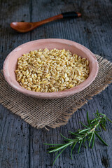 Uncooked wheat grains grown in france on rustic background