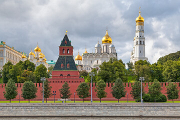 Fototapeta na wymiar The Kremlin Wall opposite the Moskva river with the Ivan the Great Bell-Tower, the Cathedral of the Archangel and the Cathedral of the Annunciation in Moscow, Russia