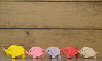 Five origami elephants in follow row