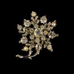 Round antique brooch with precious stones and crystals in the shape of a flower. Vintage brooch in the shape of a flower