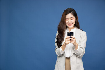 Fototapeta premium Cheerful Asian businesswoman using smartphone and receiving good news from the message on mobile chat application over white background