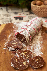 Chocolate salami on a wooden board. Christmas decor. Side view.