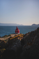 photograph of a red lighthouse on the coast, Cape Udra