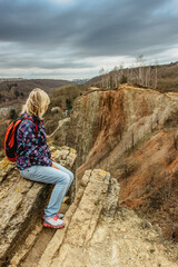 Naklejka na ściany i meble Girl with backpack enjoying view of Prokopske valley nature reserve, Prague,Czech Republic.Attractive landscape with deep valleys, local streams, dramatic limestone rocks and hiking trails.Active life