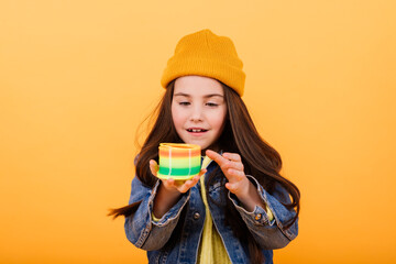 A girl  holds a multi-colored coiled toy