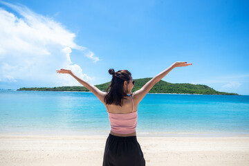 Fototapeta na wymiar Back of woman tan skin wearing pink tank top and straw hat with standing arms outstretched on sky. looking into the sea and fresh sky. Summer travel. Relax, Holiday and tropical, comfortable concept.