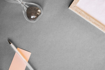 A collection of stationery on a gray background. A notebook with a pen on a gray background. Clock,...