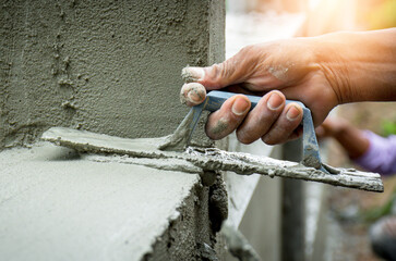 Construction workers in industrial buildings are plastering to build walls.