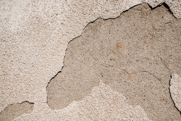 Cracked plastered cement wall as background close-up