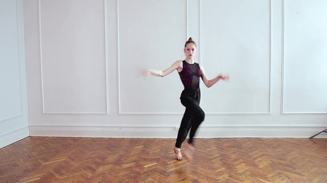 Attractive young girl dancing latino dance in studio.