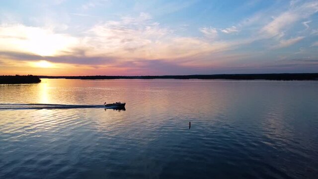 Christ Craft Boat going across screen during sunset.