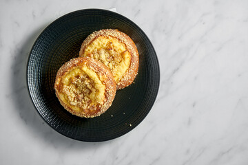 Vatrushka, cheese puff, cheese cake with raisins and cottage cheese in black plate on white marble background, Eastern European pastry