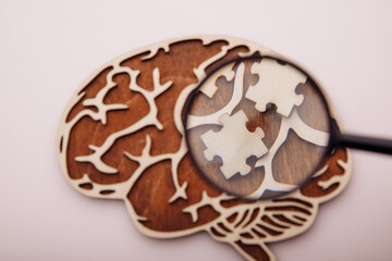 Model of brain and wooden puzzles on a pink background. Mental Health and problems with memory concept