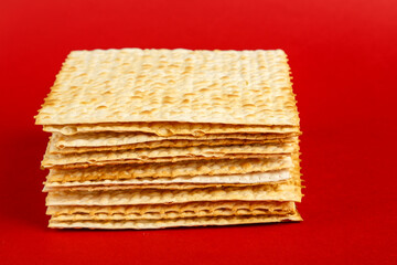 Matzo plates laid on top of each other on a red background.
