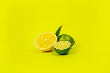 Bright summer citrus flatlay with lemons and limes isolated on yellow background.