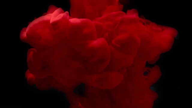 Red ink splash in water on black background