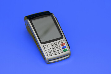 Payment terminal, compact POS terminal on blue background top view copy space