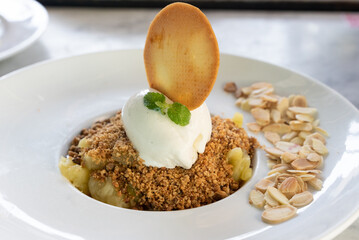 Apple crumble dessert with almonds, vanilla ice cream and biscuit. Sweet delicatessen concept