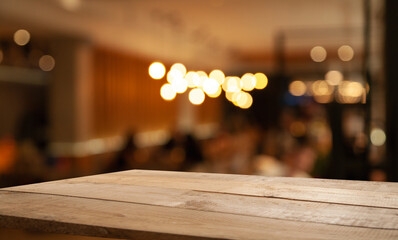image of wooden table in front of abstract blurred background of restaurant lights