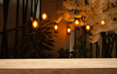 image of wooden table in front of abstract blurred background of restaurant lights