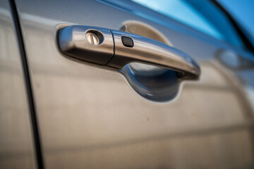 offside front door handle of a grey Suzuki motor vehicle with intentional shallow depth of field...