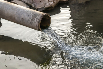 Sewer drains from a pipe into a river in the city
