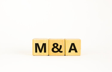 Mergers and acquisitions symbol. Concept words 'M and A - Mergers and acquisitions' on wooden cubes on a beautiful white background. Business, mergers and acquisitions concept. Copy space.