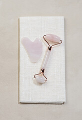Beauty Products scraper gua sha and roller in rose quartz. Flat lay, top view.