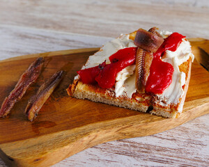 tostada de queso freso, pimiento rojo asado y anchoas del cantabrico