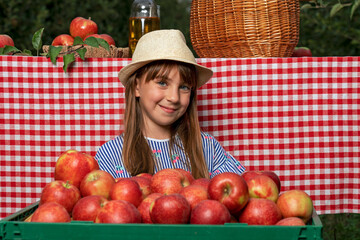 Adorable Blue Eyed Girl in Hat With Freshly Harvested Red Apples