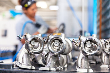 Production of vehicle part in the automotive industry, blurred female worker at work in the factory