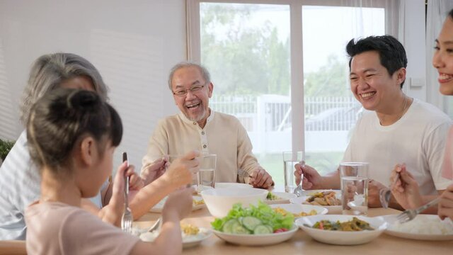 Asian big family having lunch on dining table together at home.