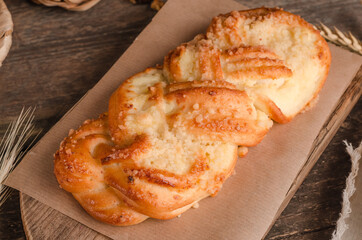 Fresh baked goods - delicious wicker bun on wooden background