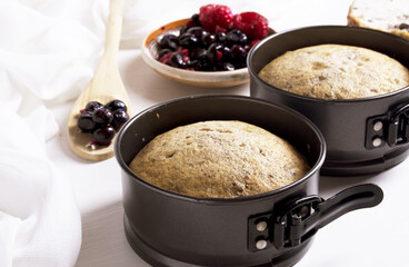  fresh baked fruit cake in metal spring form with fruits and berries on plate.